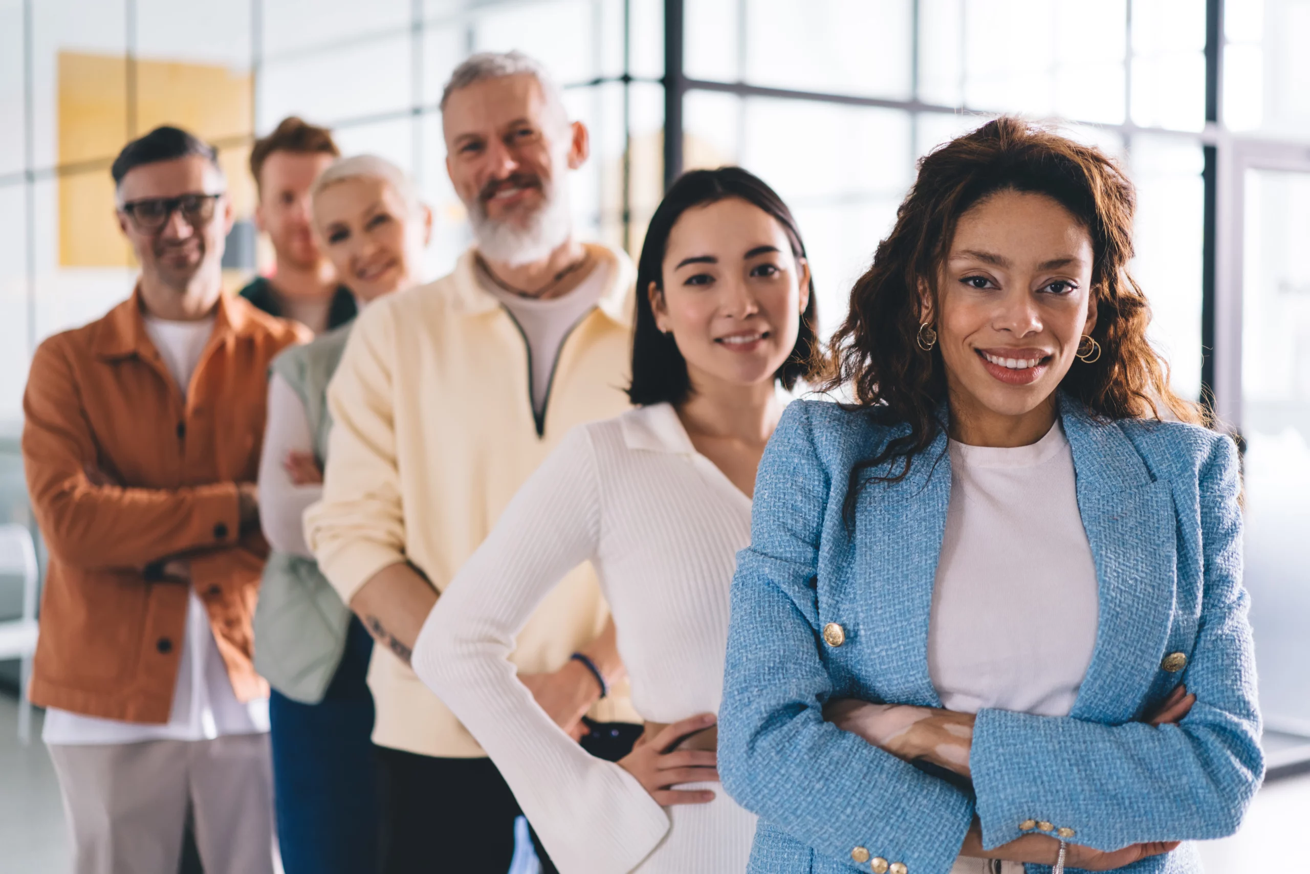 Diverse team of professionals led by a woman in a blue blazer, representing unity and fair workplace practices.